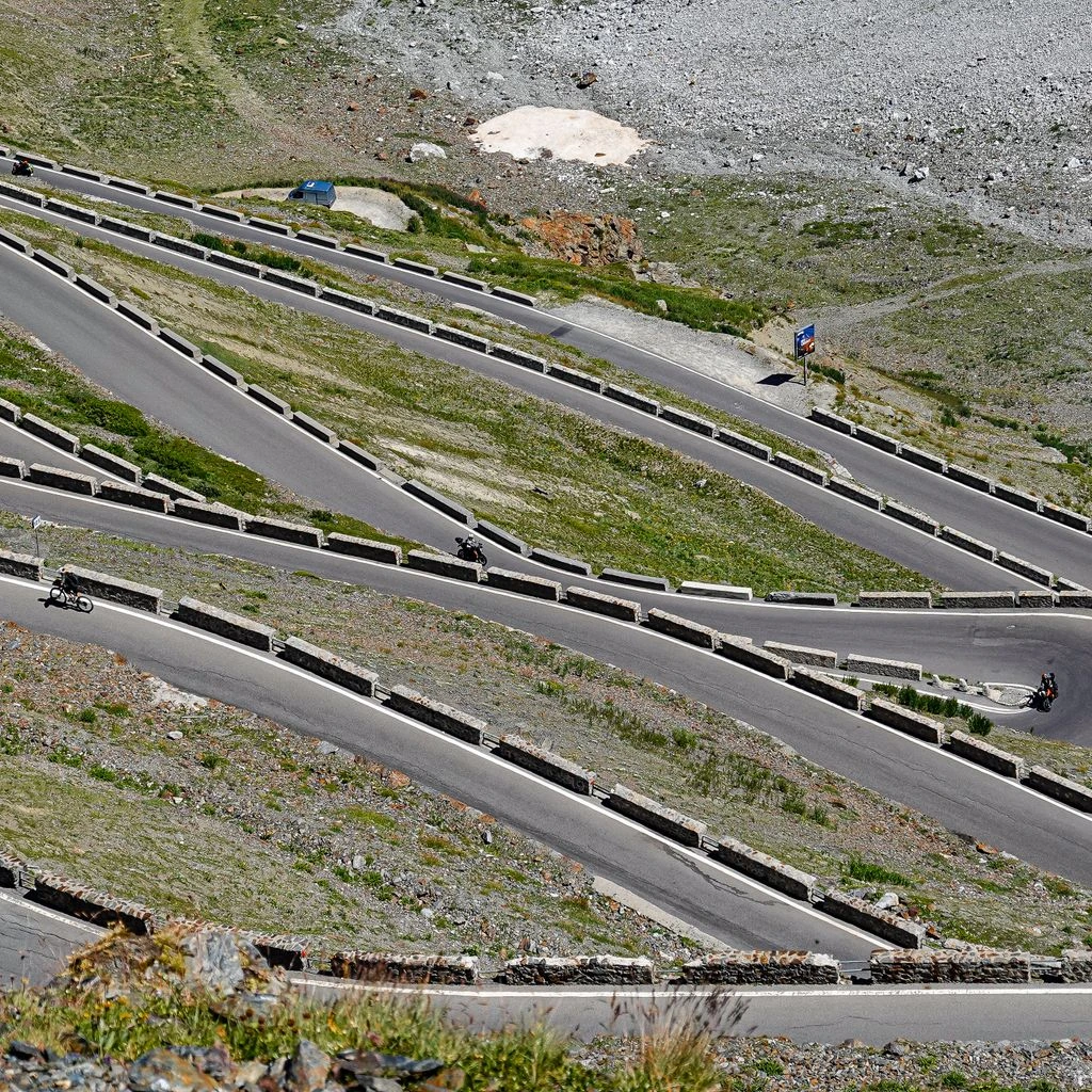 Motorcycle carving a coastal hairpin at golden hour
